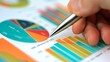 © lucegrafiar - Business Data Review. A close-up of a hand using a pen to point at a pie chart, with bar charts visible in the background.