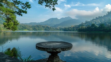 Poster - A picturesque lake surrounded by mountains and lush forest in the morning. A stone pedestal display on the water offers a natural setting for showcasing cosmetics. 