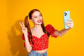 Wall Mural - Photo portrait of lovely young lady selfie photo show v-sign dressed stylish red garment isolated on yellow color background