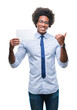 © Krakenimages.com - Afro american man holding blank card over isolated background pointing and showing with thumb up to the side with happy face smiling