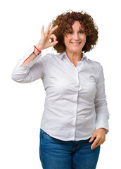 Beautiful middle ager senior businees woman over isolated background smiling positive doing ok sign with hand and fingers. Successful expression.