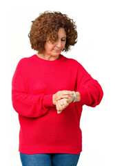 Sticker - Beautiful middle ager senior woman red winter sweater over isolated background Checking the time on wrist watch, relaxed and confident