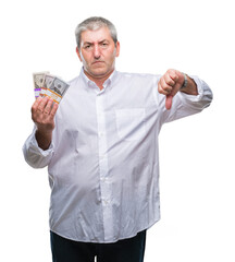 Sticker - Handsome senior man holding bunch of money over isolated background with angry face, negative sign showing dislike with thumbs down, rejection concept