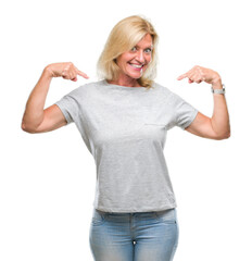 Wall Mural - Middle age blonde woman over isolated background looking confident with smile on face, pointing oneself with fingers proud and happy.