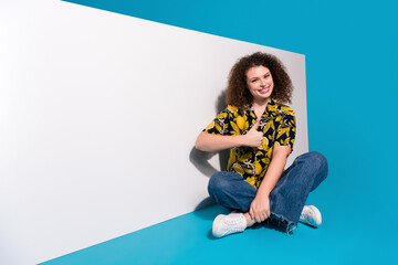 Wall Mural - Photo of charming girl wear stylish clothes recommend white banner thumb up empty space isolated on blue color background