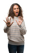 © Krakenimages.com - Beautiful young hispanic woman wearing stripes sweater afraid and terrified with fear expression stop gesture with hands, shouting in shock. Panic concept.