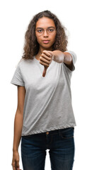 Canvas Print - Beautiful young hispanic woman wearing glasses looking unhappy and angry showing rejection and negative with thumbs down gesture. Bad expression.