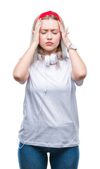 Canvas Print - Young blonde woman wearing headphones listening to music over isolated background suffering from headache desperate and stressed because pain and migraine. Hands on head.