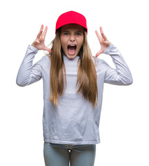 Wall Mural - Young beautiful girl wearing red cap isolated background celebrating mad and crazy for success with arms raised and closed eyes screaming excited. Winner concept