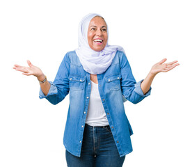 Wall Mural - Middle age eastern arab woman wearing arabian hijab over isolated background Smiling showing both hands open palms, presenting and advertising comparison and balance