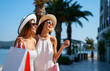 © NDABCREATIVITY - Fashionable women out on the street with shopping bags enjoying summer vacation and travel.
