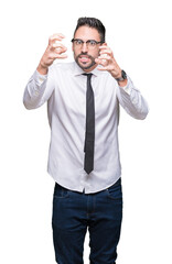 Sticker - Young handsome business man wearing glasses over isolated background Shouting frustrated with rage, hands trying to strangle, yelling mad