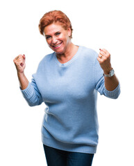 Sticker - Atrractive senior caucasian redhead woman over isolated background very happy and excited doing winner gesture with arms raised, smiling and screaming for success. Celebration concept.