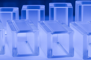 Poster - Transparent glass blocks arranged in a symmetrical pattern with a blue tint. 3d rendering