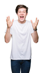 Poster - Young handsome man wearing casual white t-shirt over isolated background celebrating crazy and amazed for success with arms raised and open eyes screaming excited. Winner concept