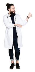 Wall Mural - Doctor with long hair wearing medical coat and stethoscope Looking proud, smiling doing thumbs up gesture to the side