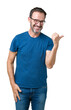 © Krakenimages.com - Handsome middle age hoary senior man wearin glasses over isolated background smiling with happy face looking and pointing to the side with thumb up.