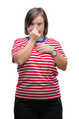 Sticker - Young adult woman with down syndrome over isolated background smelling something stinky and disgusting, intolerable smell, holding breath with fingers on nose. Bad smells concept.