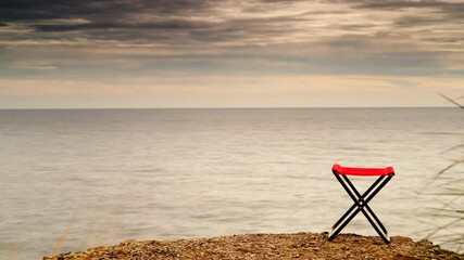 Sticker - Time lapse of clouds moving over empty folding camp chair on beach nature. Holidays relaxation on trip. Vacation in the camping.
