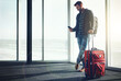 © ReeseArcurs/peopleimages.com - Travel, relax and man with phone, suitcase and time for chat in airport, journey and online in waiting room. Reading, message and person with mobile, communication and trip of holiday and vacation