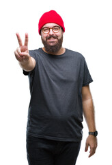 Wall Mural - Young caucasian hipster man wearing glasses over isolated background smiling with happy face winking at the camera doing victory sign. Number two.