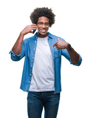 Wall Mural - Afro american man talking on the phone over isolated background with surprise face pointing finger to himself