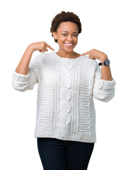 Wall Mural - Beautiful young african american woman wearing sweater over isolated background looking confident with smile on face, pointing oneself with fingers proud and happy.