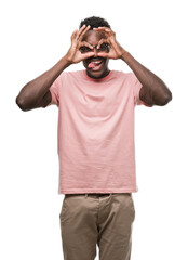 Canvas Print - Young african american man wearing pink t-shirt doing ok gesture like binoculars sticking tongue out, eyes looking through fingers. Crazy expression.