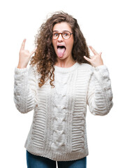 Wall Mural - Beautiful brunette curly hair young girl wearing winter sweater over isolated background shouting with crazy expression doing rock symbol with hands up. Music star. Heavy concept.