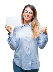 Poster - Young beautiful business woman holding blank card over isolated background pointing and showing with thumb up to the side with happy face smiling