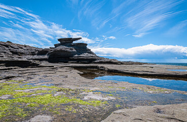 Limestone plateaus with sculptural formations under a sweeping sky create a serene tableau at Mingan Archipelago National Park Reserve.