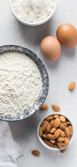 Wall Mural - overhead view of mise en place for almond biscotti dough, ingredients for making almond cantucci cookie on a marble countertop