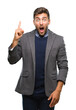 © Krakenimages.com - Young handsome business man over isolated background pointing finger up with successful idea. Exited and happy. Number one.