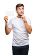 © Krakenimages.com - Young handsome man holding blank card over isolated background serious face thinking about question, very confused idea