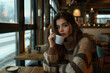 © Neyro - Young woman holding a cup of coffee in cozy café, sitting by window, enjoying drink and view, warm inviting atmosphere with copy space