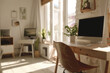 © Victor Bertrand - Sunlit home office with a sleek computer setup, potted plants, and a cozy atmosphere.