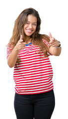 Poster - Young beautiful brunette woman wearing stripes t-shirt over isolated background pointing fingers to camera with happy and funny face. Good energy and vibes.