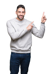 Canvas Print - Young handsome man wearing sweatshirt over isolated background smiling and looking at the camera pointing with two hands and fingers to the side.