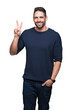 © Krakenimages.com - Young handsome man wearing sweater over isolated background showing and pointing up with fingers number two while smiling confident and happy.
