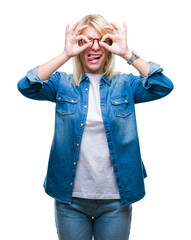 Sticker - Young beautiful blonde woman wearing glasses over isolated background doing ok gesture like binoculars sticking tongue out, eyes looking through fingers. Crazy expression.