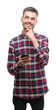© Krakenimages.com - Young hipster adult man holding smartphone serious face thinking about question, very confused idea