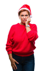 Poster - Atrractive senior caucasian redhead woman wearing christmas hat over isolated background looking stressed and nervous with hands on mouth biting nails. Anxiety problem.