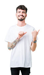 Poster - Young handsome man wearing white t-shirt over isolated background Pointing to the back behind with hand and thumbs up, smiling confident