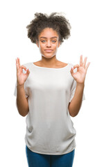 Poster - Young afro american woman over isolated background relax and smiling with eyes closed doing meditation gesture with fingers. Yoga concept.