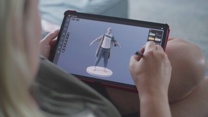 Poster - Caucasian woman creates model in 3D modeling design app using tablet computer and digital pen. Adult woman makes freelance working project lying on sofa at home. Lifestyle and remote work. Close Up.