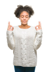 Canvas Print - Young afro american woman wearing winter sweater over isolated background relax and smiling with eyes closed doing meditation gesture with fingers. Yoga concept.