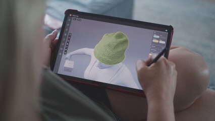 Aufkleber - Woman draws and creates clothes in 3D modeling design application using digital tablet and stylus. Caucasian woman makes remote work project lying on couch at home. Lifestyle and freelance. Close Up.