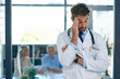 © SensSai/peopleimages.com - Hospital, doctor and man with headache, stress and worry for medical career, job and work with patients. Professional, healthcare and person with pain for overworked, burnout and frustrated in clinic
