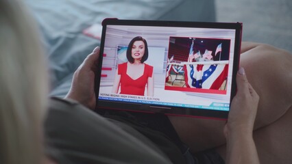 Poster - close up of tv news broadcast with female news anchor displayed on tablet screen. caucasian woman wa