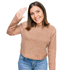 Wall Mural - Young beautiful woman wearing casual clothes waiving saying hello happy and smiling, friendly welcome gesture